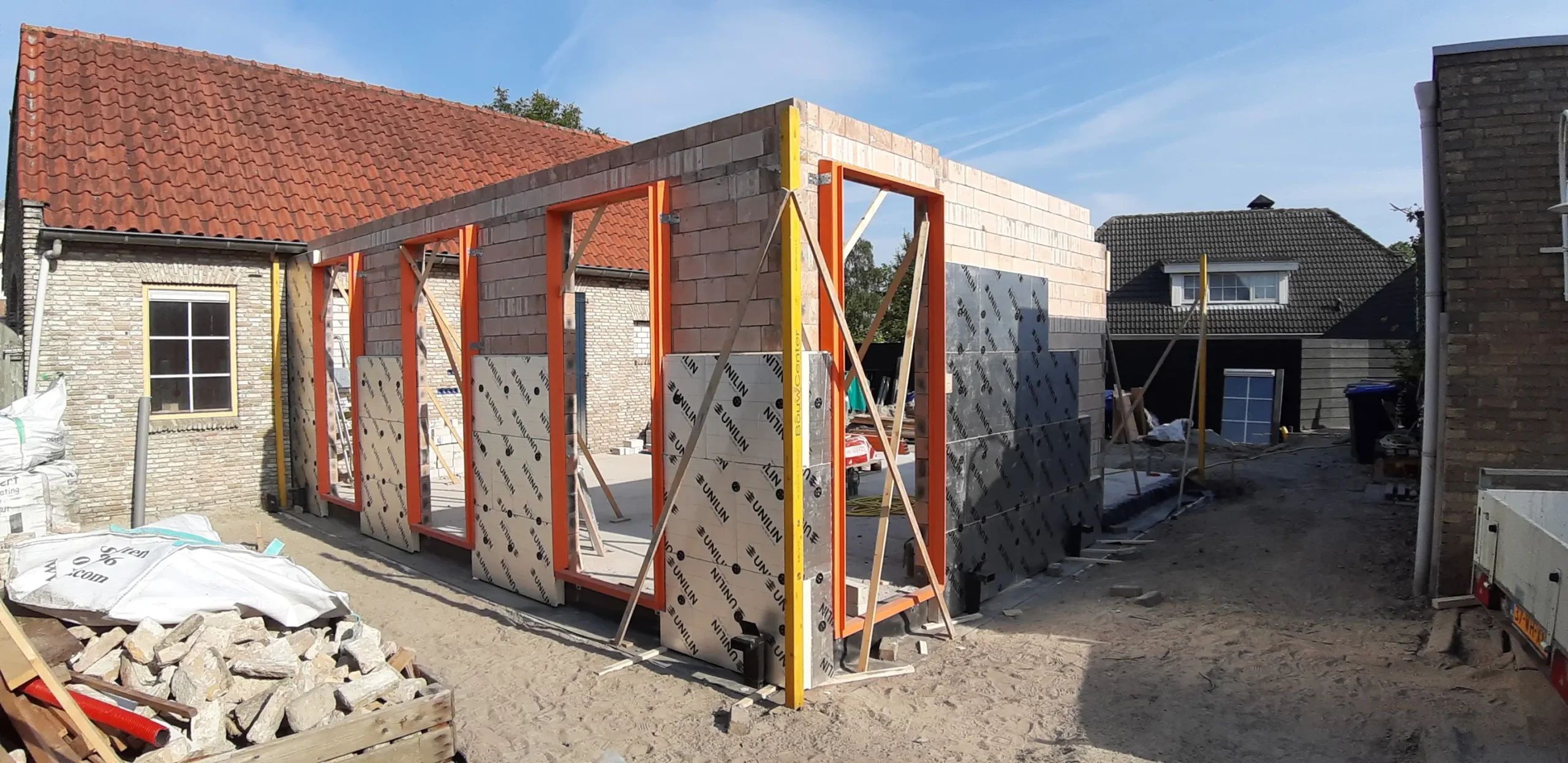 Plaatsen van de muren en isolatie van de aanbouw bij de woning in Langeweg
